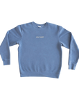 A dusty blue crewneck sweatshirt with 'GOLF SHIRT.' embroidered in small white text on the chest, displayed flat against a solid white background.