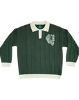 A dark green ribbed knit rugby sweater with a cream collar, cuffs, and hem, featuring a white embroidered lion head on the left chest.