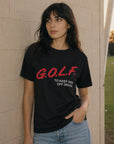 A woman wearing a black graphic t-shirt with red and white text reading 'G.O.