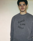 Man wearing a gray sweatshirt with 'GOOD LION GOLF' text against a plain background