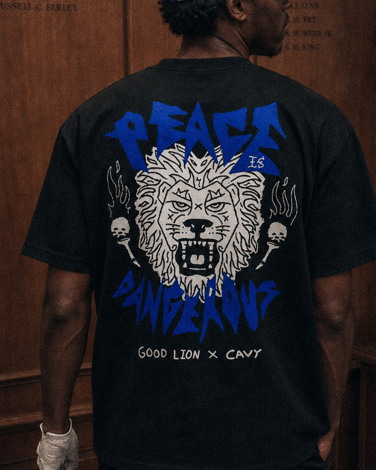 Person wearing a black t-shirt with a graphic design and text on the back.