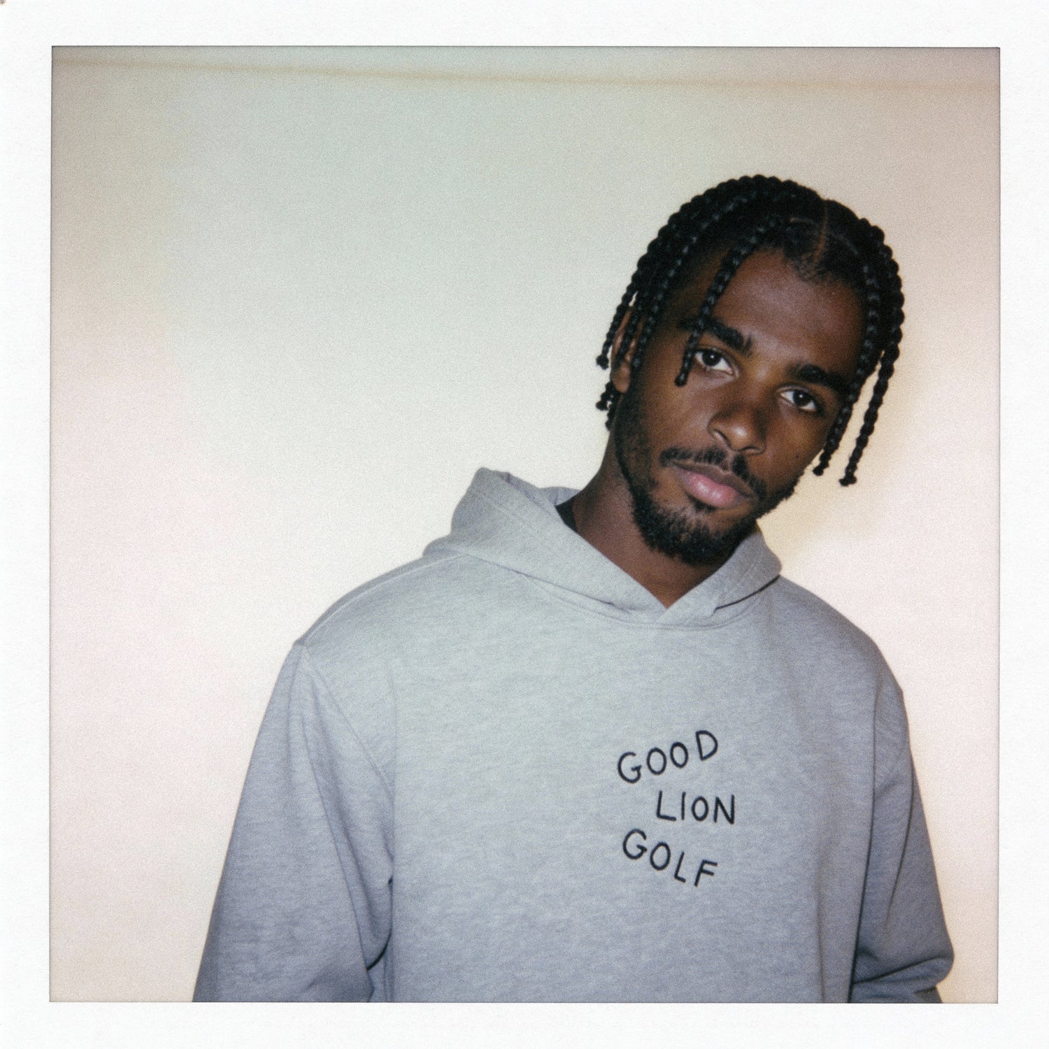 Man wearing a gray hoodie with 'Good Lion Golf' text against a plain background