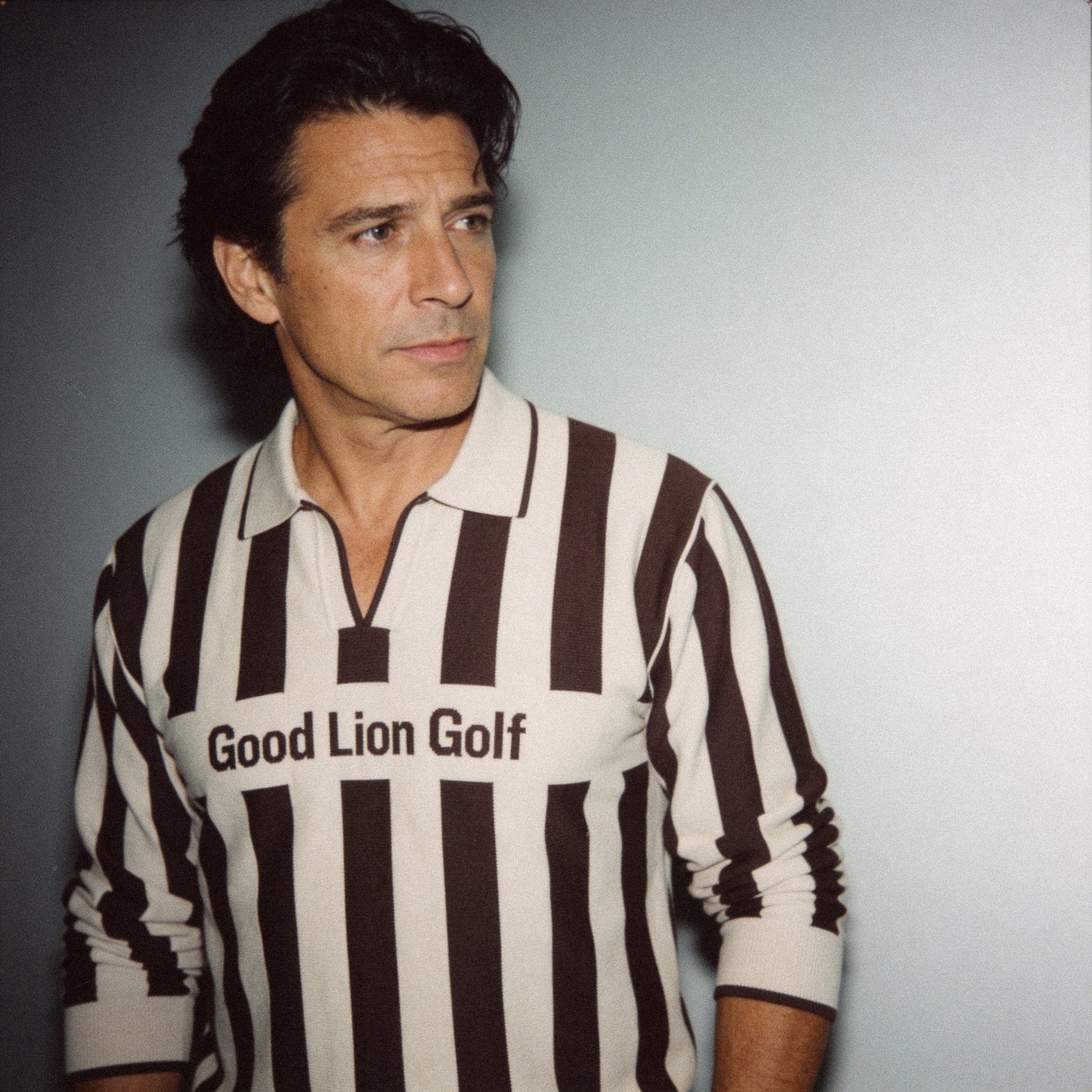 Man wearing a brown and white striped shirt with 'Good Lion Golf' text against a plain background