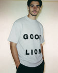 Person wearing a gray t-shirt with 'GOOD LION' text against a plain background