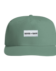 Green cap with a white patch displaying 'GOOD > SAFE' on a white background